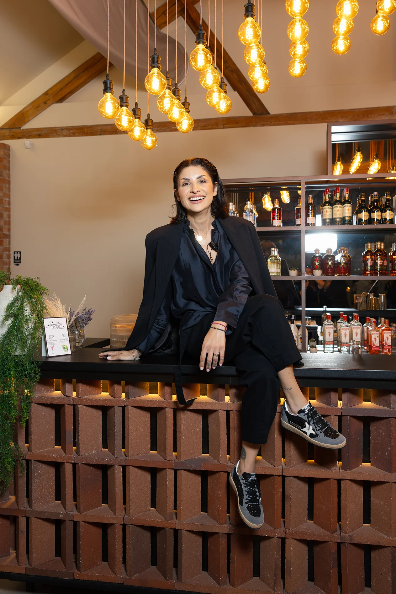 Giulia at an event beneath pendant lights